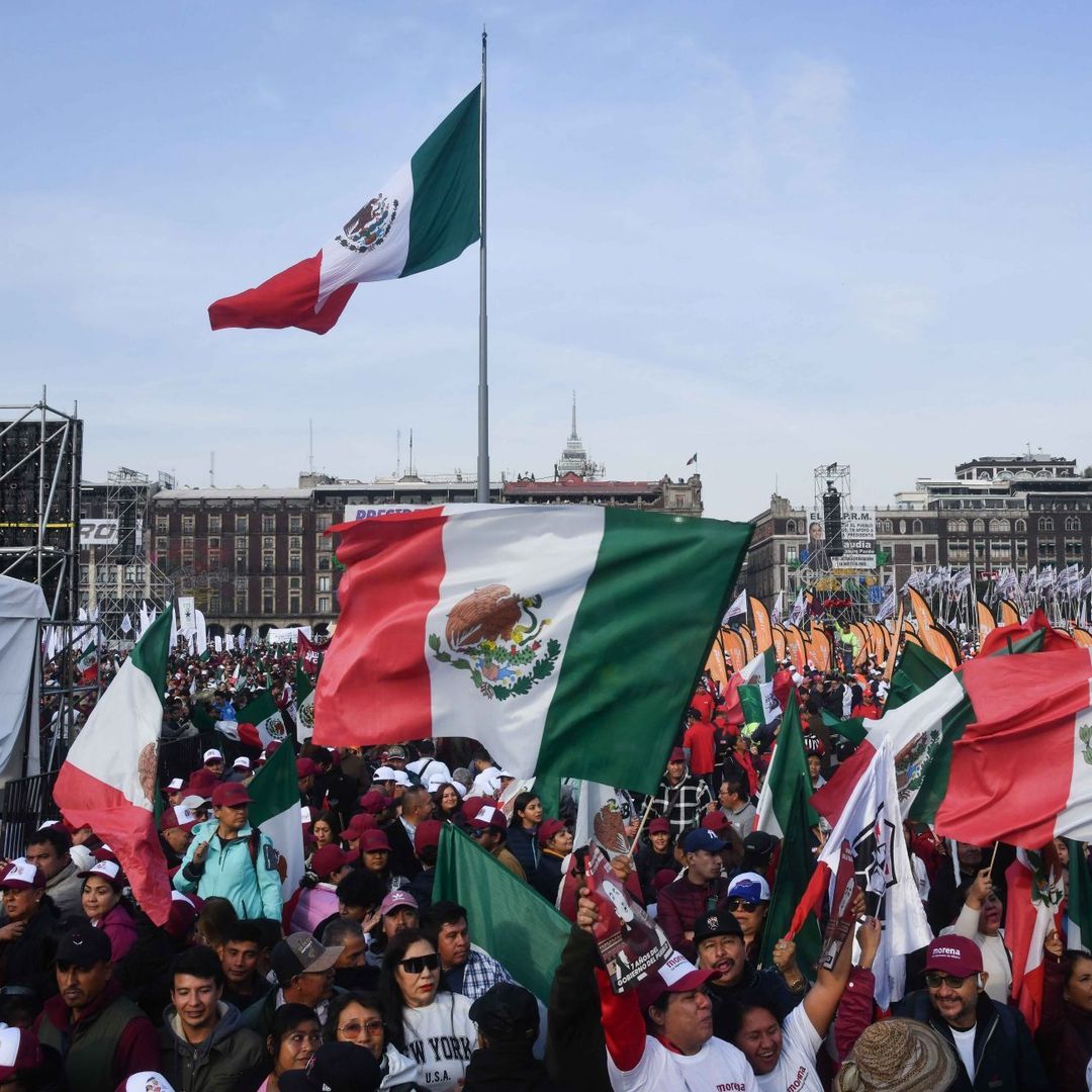 Gente con banderas en el zócalo de cdmx asiste al Zócalo